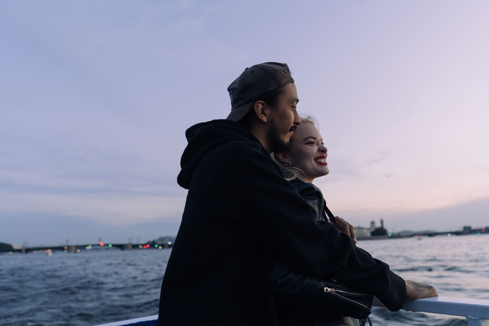 Couple sharing a cabin-mate moment at the rail of a boat at dusk, the travelers a second guest free cruise is made for