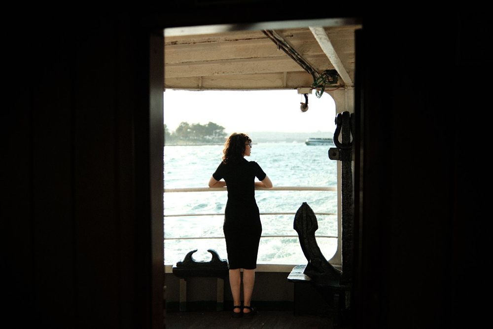 Traveler silhouetted in a ship doorway looking out to sea